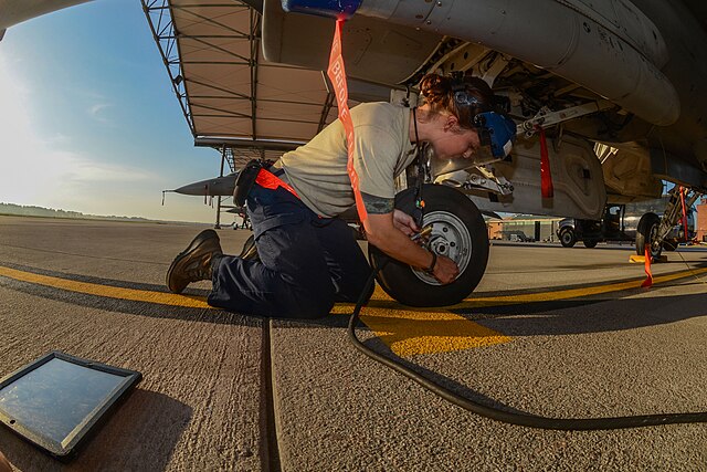 This is US Air Force Staff Sgt Angelyn Dominguez servicing a tire on a F-16 Fighting Falcon jet