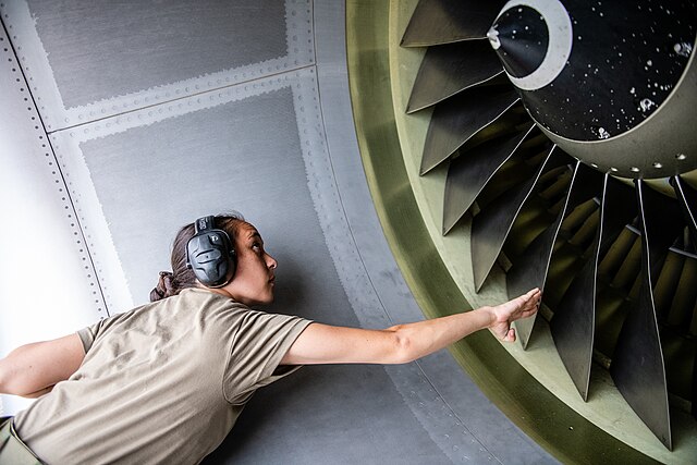 Woman Inspects Turbines of an Aircraft Engine