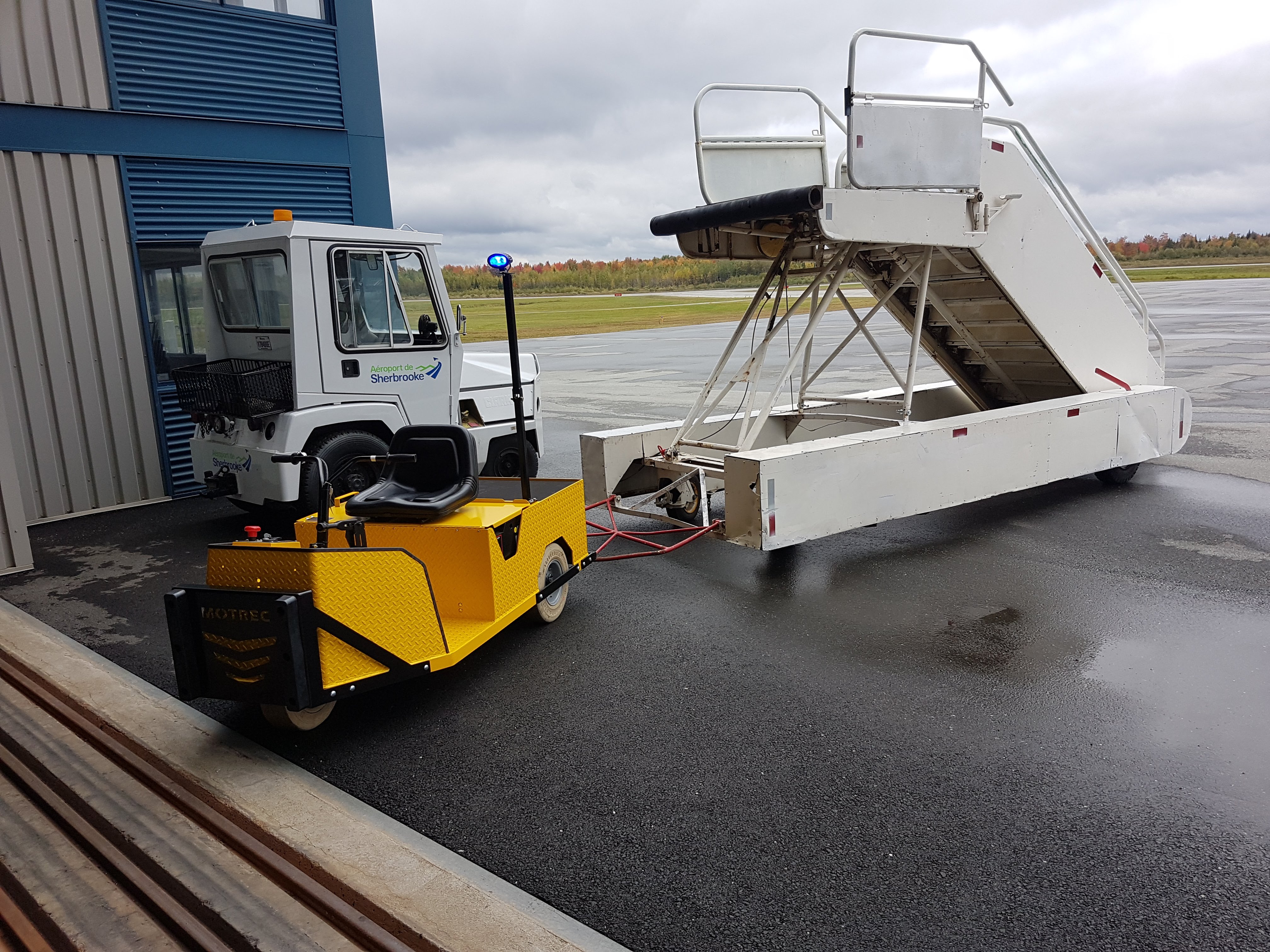Customized Motrec Electric Vehicle Towing Passenger Stairs at an Airport