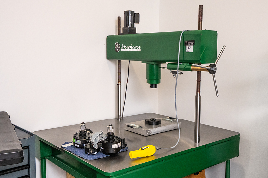 Surface plate with a green calibration stand and measurement fixtures used for precision testing.