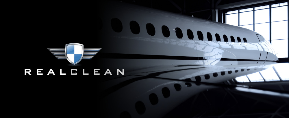 The RealClean Aviation Products Logo overlaying a black gradient background with an image of a shiny plane to the right.