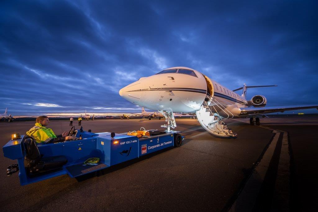 Electric Towbarless Tug Towing an Aircraft at Sunset